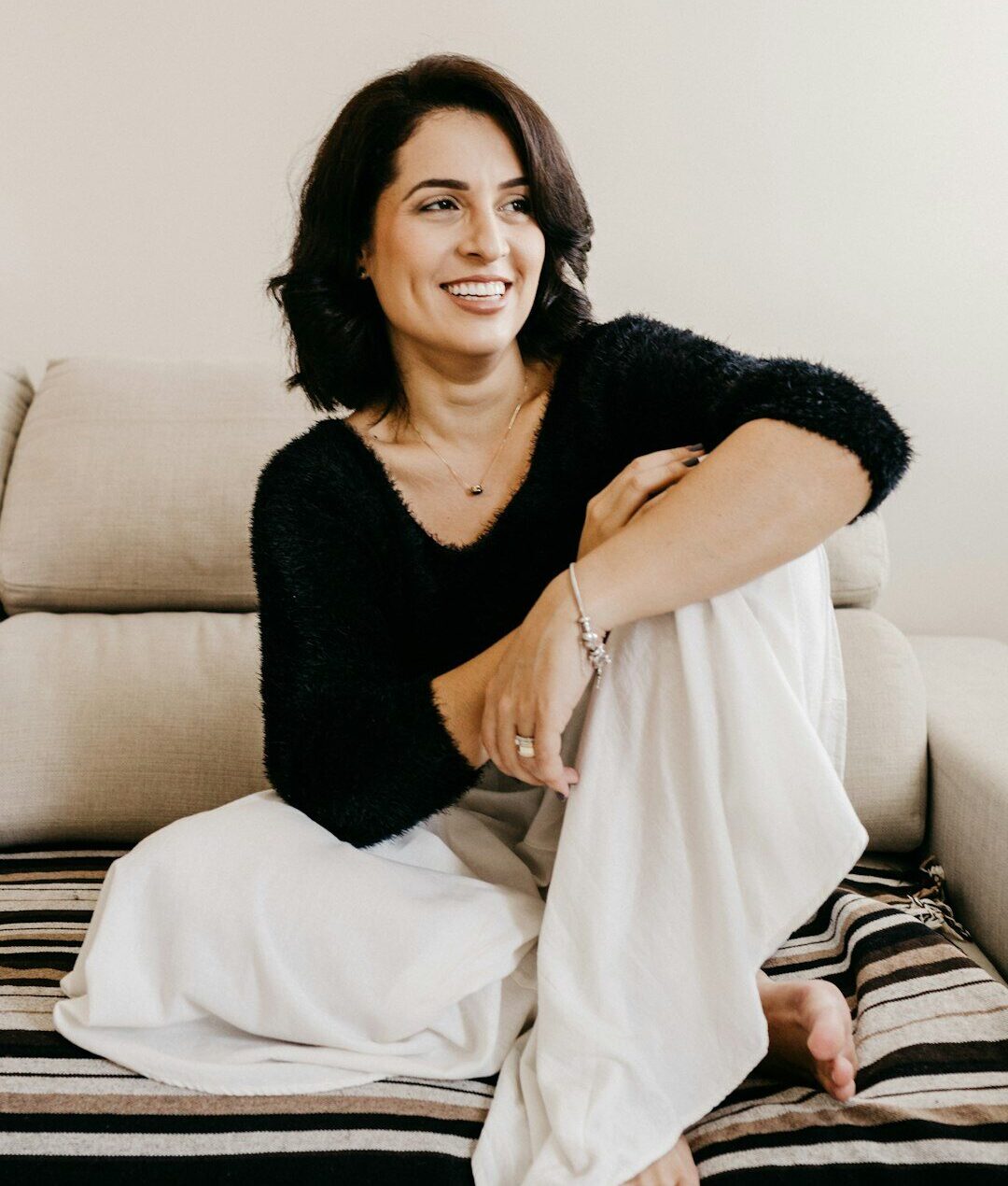 woman in black long sleeve shirt sitting on white couch